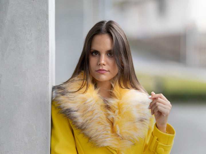 Mulher jovem com casaco amarelo da marca Fracomina.